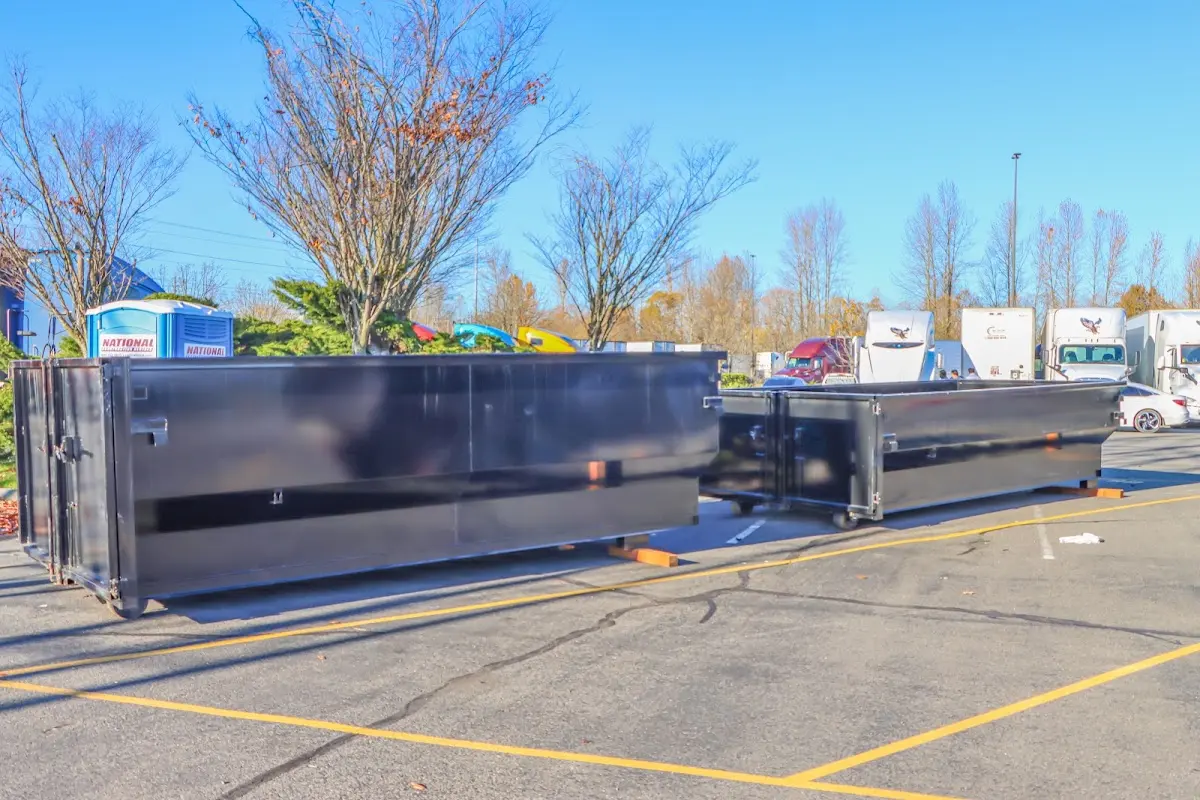 Professional dumpster rental service with roll-off container on residential driveway in Fort Lee